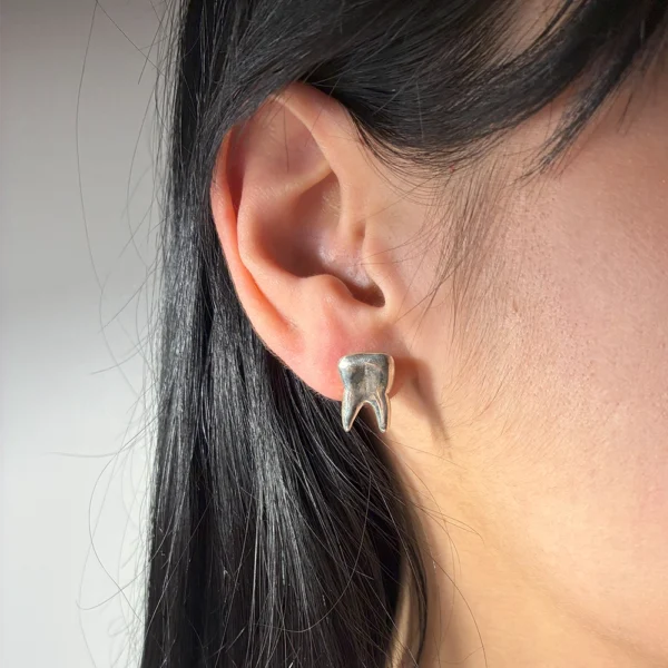 Bite Sisters earrings in silver, worn on ears