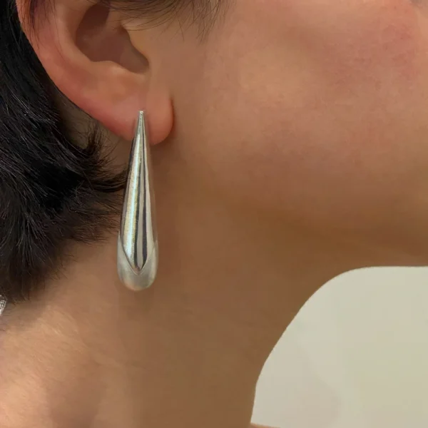 Queen Root earring in silver, worn on ear