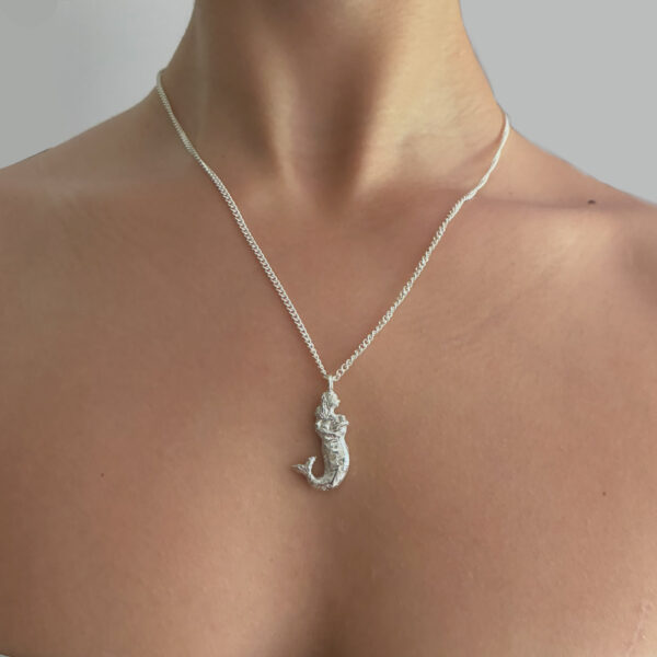 Model wearing silver mermaid pendant